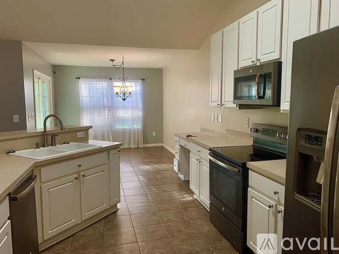 A kitchen with white cabinets and brown appliances.