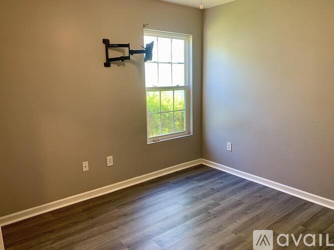 A room with a window and a wooden floor.