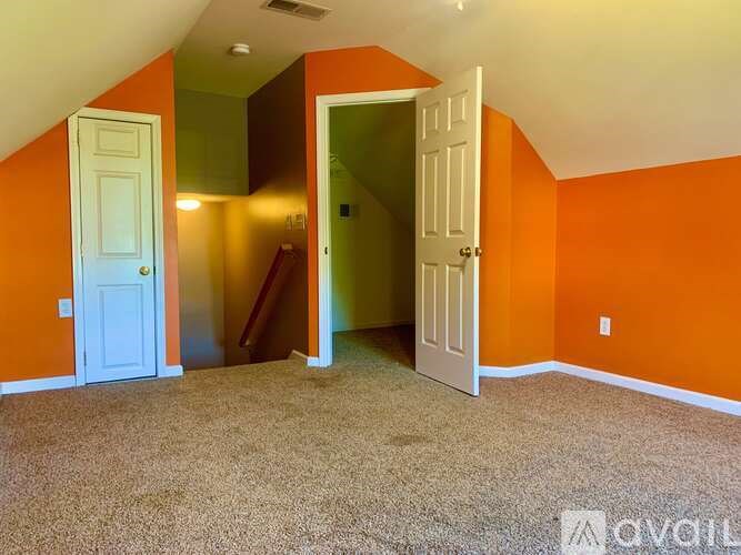 A room with orange walls and a carpeted floor.