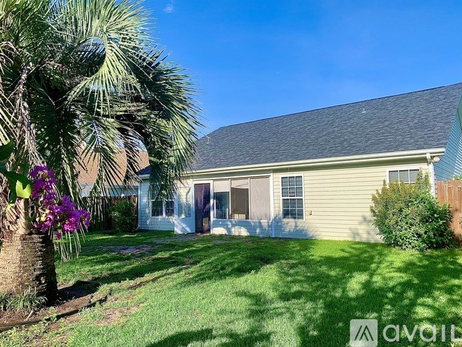 A house with a well-kept lawn and a palm tree in front.