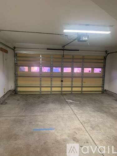 A garage with a yellow door and a blue line on the floor.