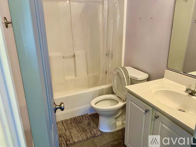 A bathroom with a toilet, sink, and shower.