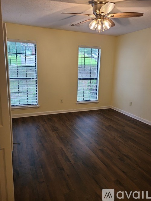 A room with wooden floors and a ceiling fan.