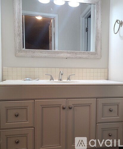 A bathroom vanity with a sink and a mirror above it.