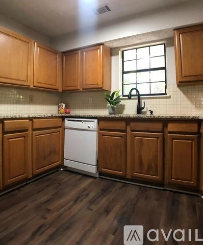 A kitchen with wooden cabinets and a white dishwasher.