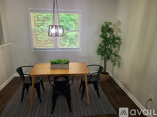 A dining room with a wooden table and chairs.