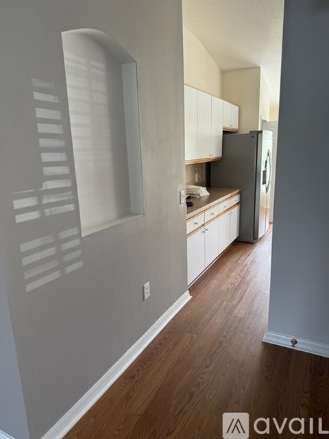 A kitchen with white cabinets and a refrigerator.