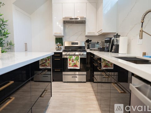 A modern kitchen with white cabinets and stainless steel appliances.