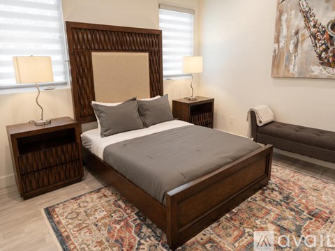 A bedroom with a large bed and a painting on the wall.