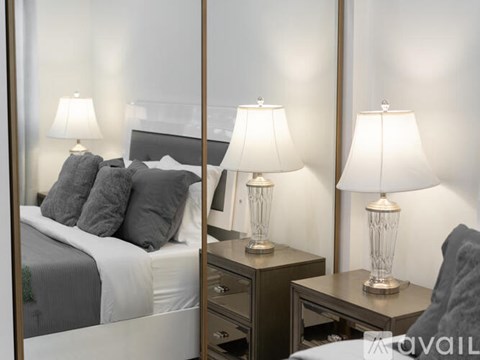 A bedroom with a bed, nightstand, and two lamps.