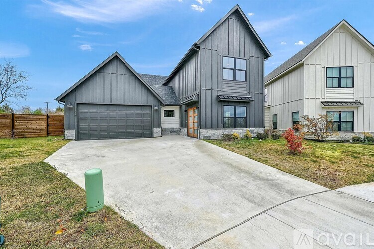 A modern house with a grey garage door is for sale.