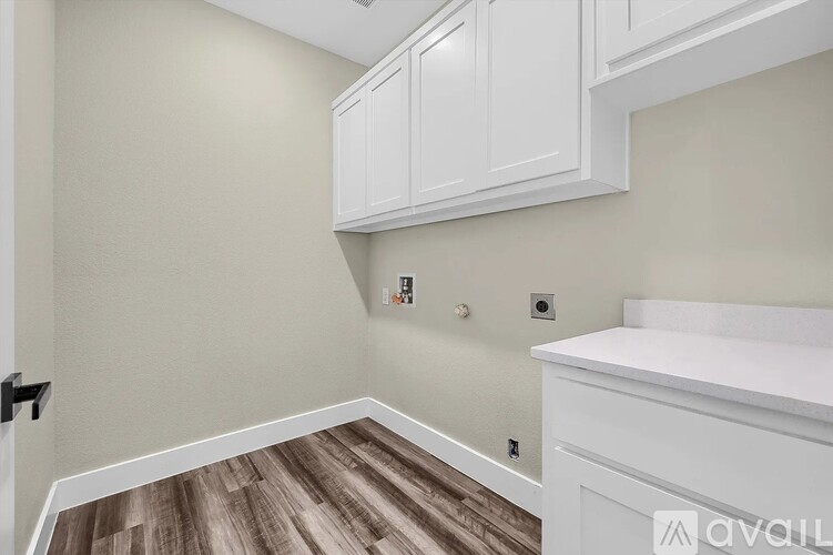 A kitchen with white cabinets and a wooden floor.