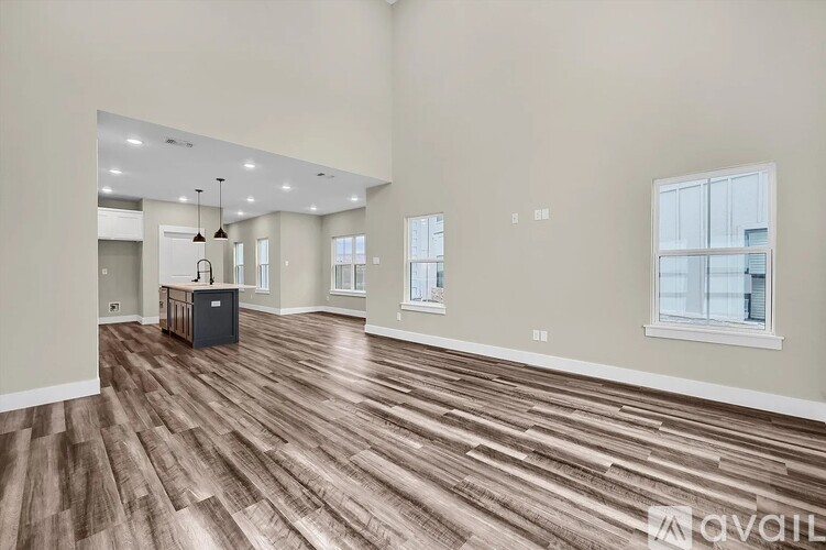 A spacious room with wooden flooring and a large window.
