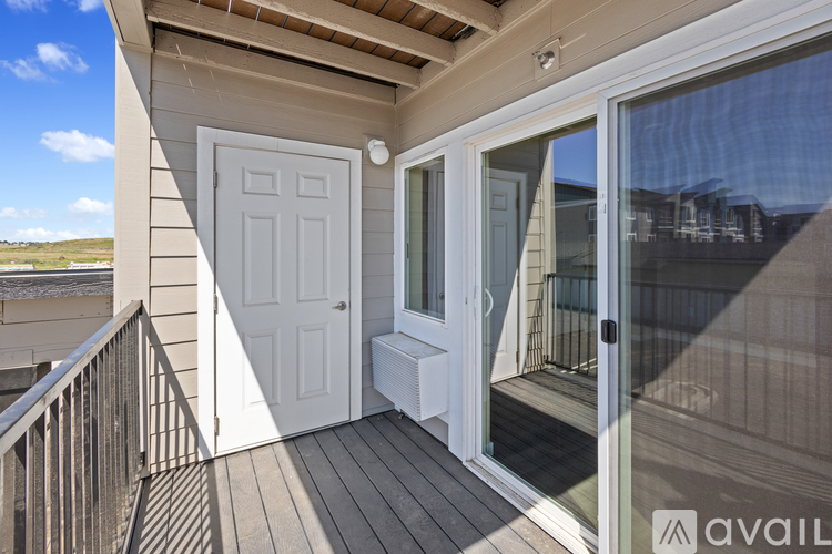 A balcony with a white door and a glass window.