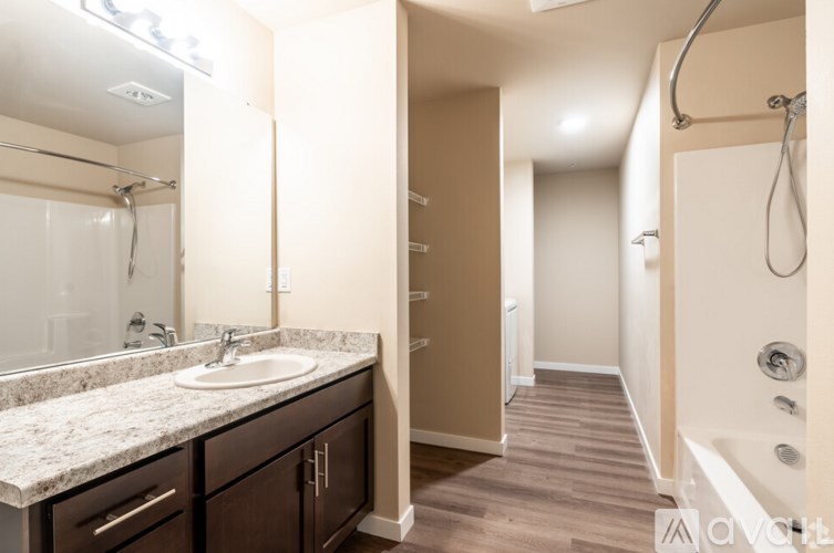 A bathroom with a sink, mirror, and bathtub.