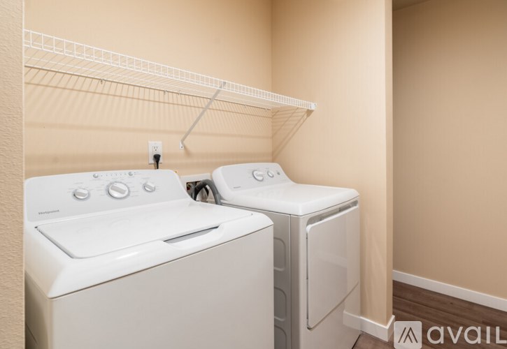 A white dryer and washer are sitting next to each other in a laundry room.