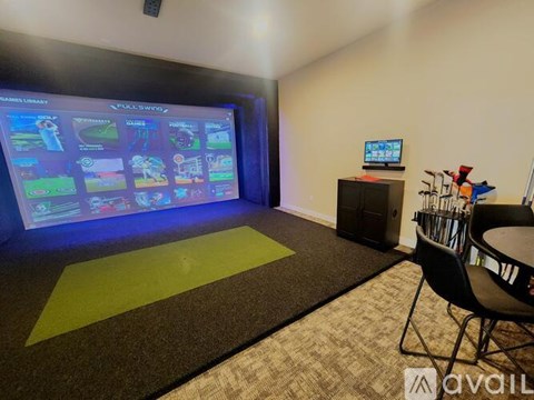A room with a large screen displaying a video game interface.