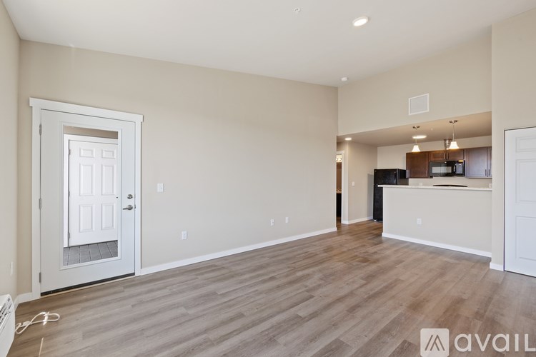 A spacious living room with a door leading to another room.