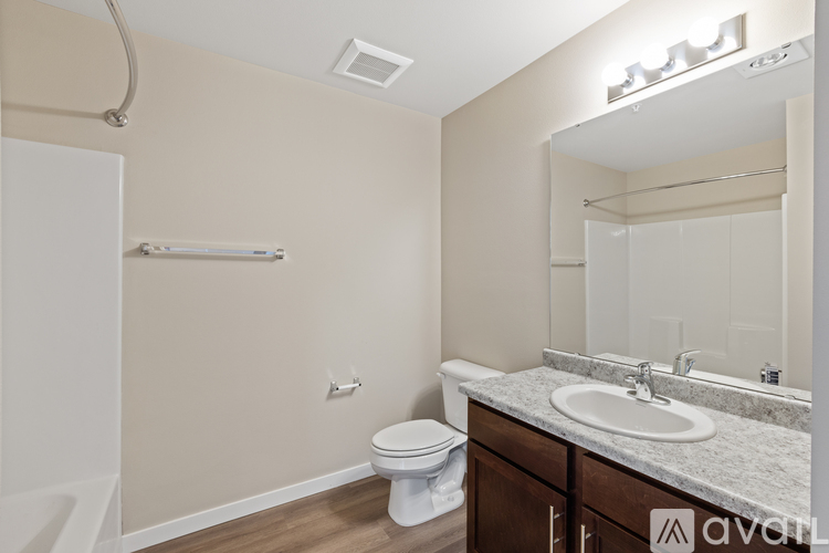 A bathroom with a toilet, sink, and mirror.