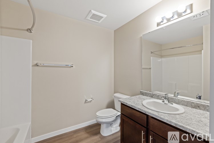 A bathroom with a toilet, sink, and mirror.