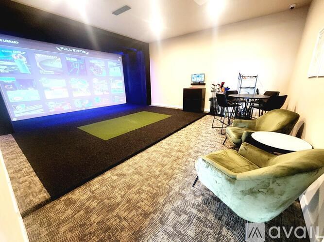 A home theater room with a screen, chairs, and a table.