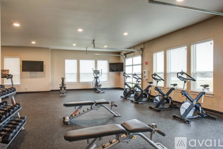 A gym with a variety of exercise equipment including treadmills, stationary bikes, and weight machines.