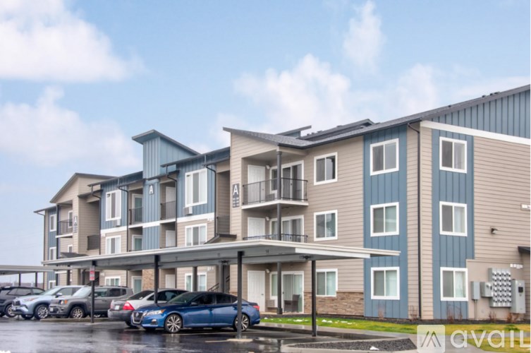 A multi-story apartment building with a car parked in front.
