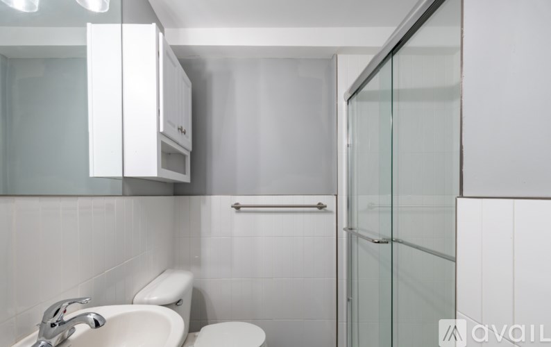 A white bathroom with a glass shower door.