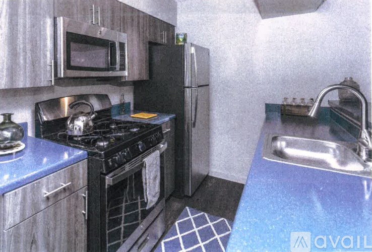 A kitchen with a stove, refrigerator, and microwave.