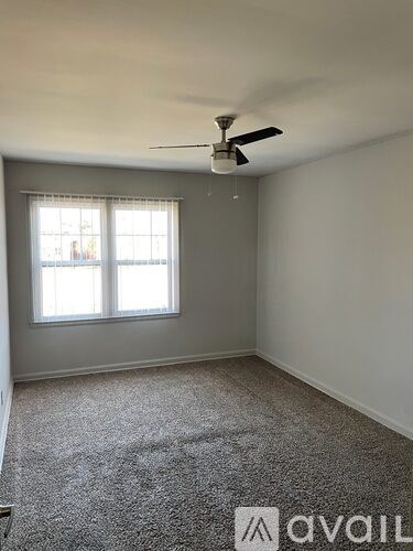 A room with a ceiling fan and a window.