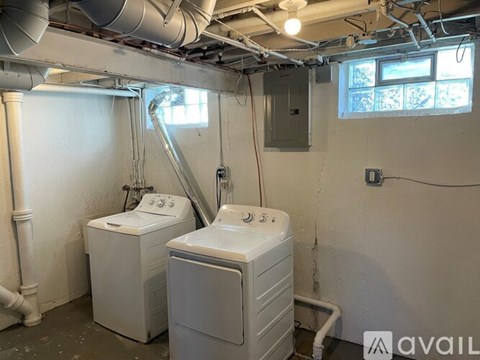 A room with two washing machines and a window.