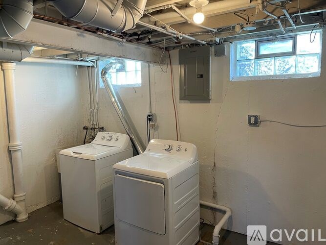 A room with two washing machines and a window.