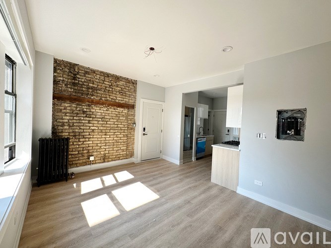 A room with a brick wall and wooden flooring.
