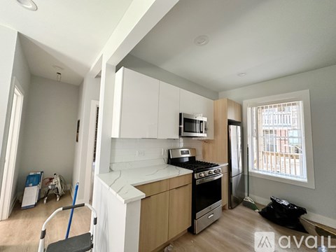 A kitchen with white cabinets and a black stove top oven.