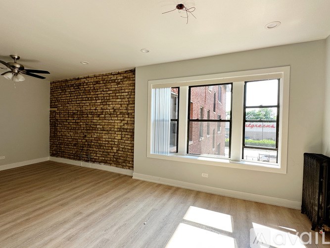 A room with a brick wall and a ceiling fan.