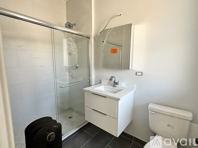 A bathroom with a toilet, sink, and shower.