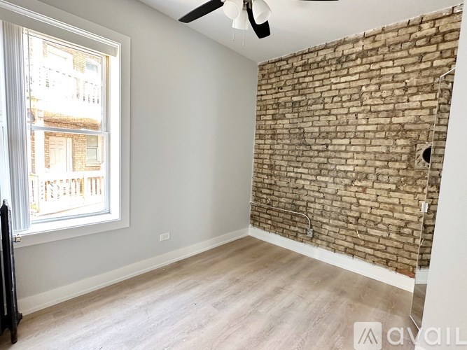 A room with a brick wall and a window.