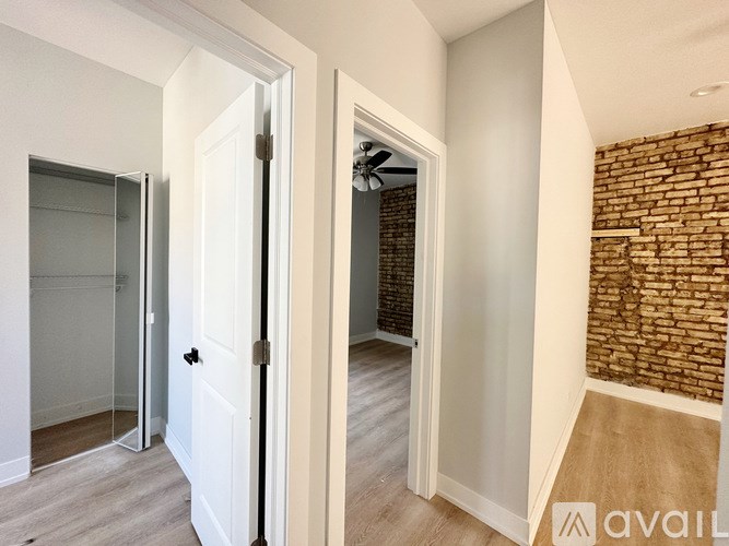 A room with a brick wall and a white door.