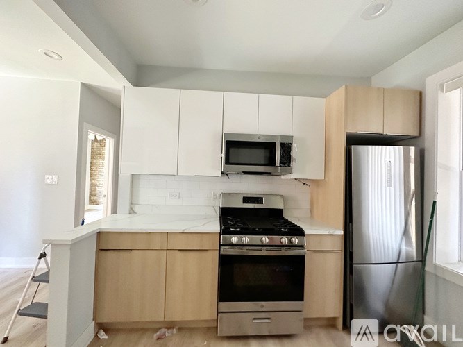 A kitchen with a stove, microwave, and refrigerator.