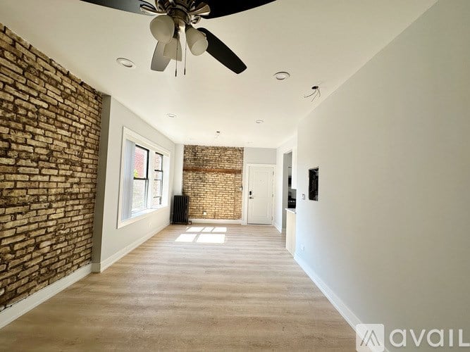 A room with a brick wall and a ceiling fan.
