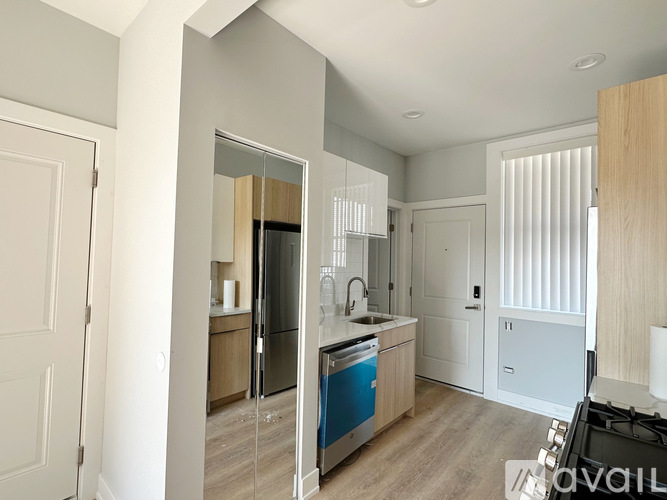 A modern kitchen with a blue dishwasher and wooden cabinets.