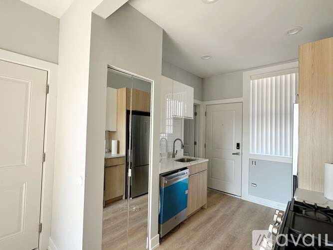 A modern kitchen with a blue dishwasher and wooden cabinets.