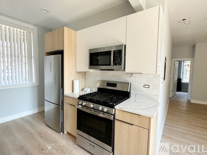 A kitchen with a stove, oven, refrigerator, and microwave.