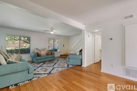 A living room with a blue couch and a rug.