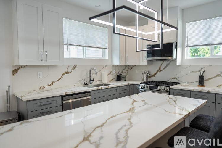 A kitchen with a marble countertop and modern appliances.