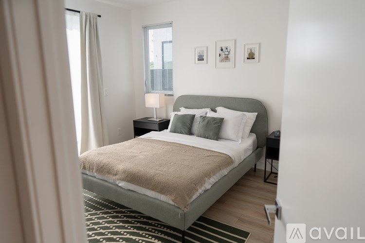 A bedroom with a bed, nightstand, and pictures on the wall.