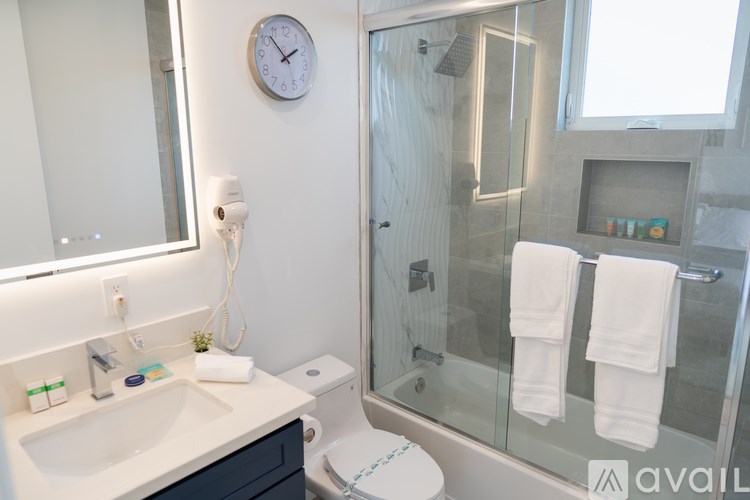 A bathroom with a white sink and a glass shower stall.