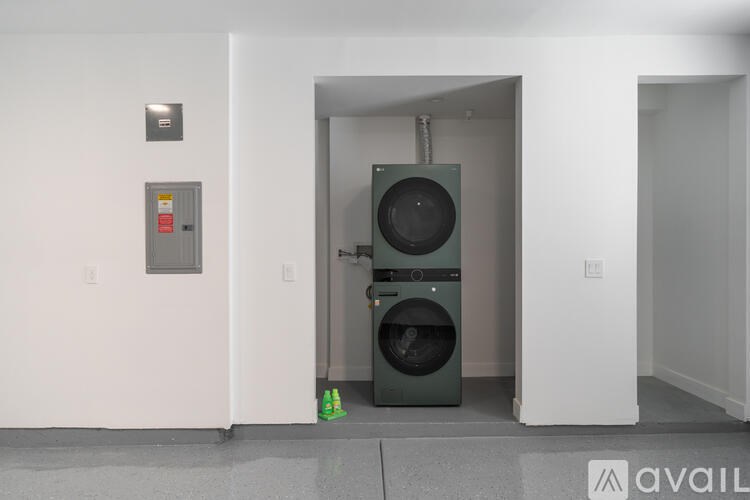 A washing machine is in the doorway of a room.