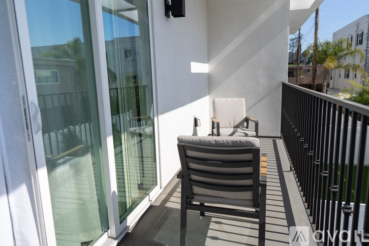 A chair is on a balcony with a glass door.