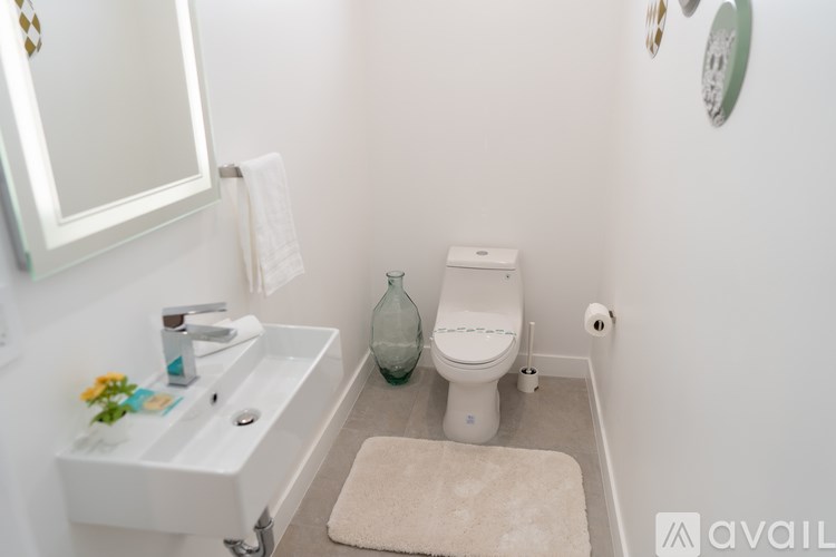 A bathroom with a toilet, sink, and mirror.